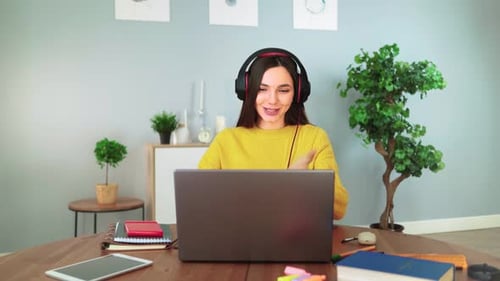 Woman in Yellow Sweater Talking on Laptop