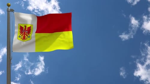 Waving Flag with Coat of Arms Against Blue Sky