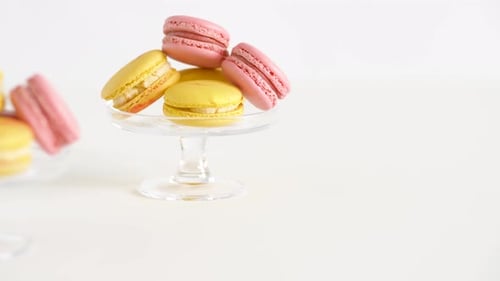 Gelbe und rosa Macarons auf Glasständern