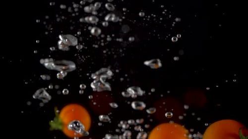 Cherry Tomatoes Falling into Water in Slow Motion