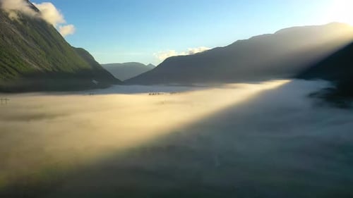 Morgennebel über dem Tal Unter den Bergen im Sonnenlicht