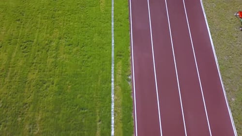 Top view of red running tracks and green grass lawn. Infrastructaure for sports activities