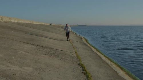 Slim Man Is Running Near Lake