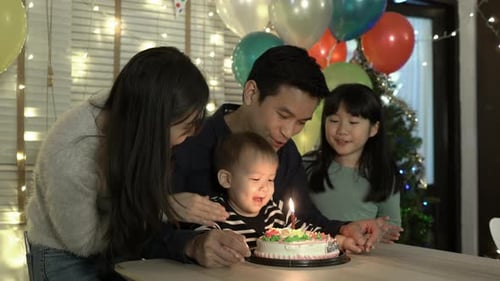 Family Celebrates Toddler's Birthday at Home with Cake