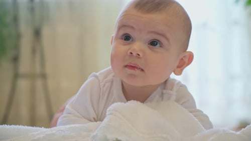 Cute Infant Lying on Blanket in Bright Room