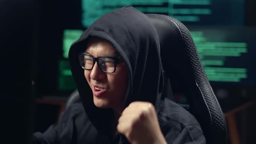 Erfolgreicher asiatischer männlicher Hacker, der Computer-Hacking nutzt