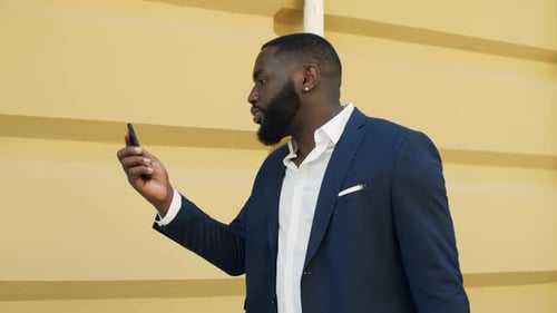 Man Using Phone Outside a Building