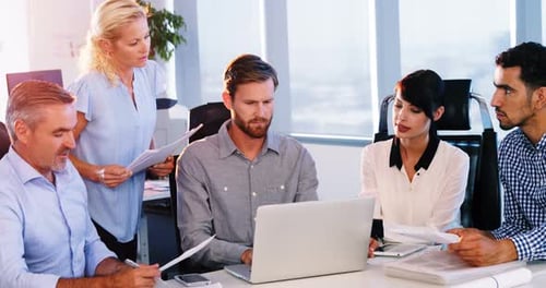 Team Working Together Around Table With Laptop