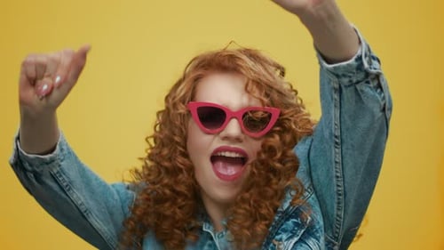 Stylish Young Woman Dancing Energetically in Sunglasses