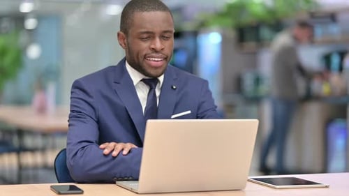 Happy African Businessman Doing Video Call on Laptop in Office