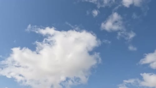 Weiße Wolken fliegen auf blauem Himmel mit Sonnenstrahlen