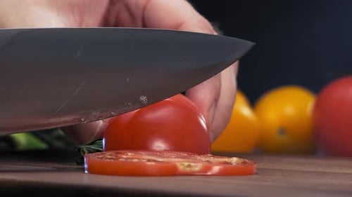 Vibrant Tomato Being Sliced with Silver Knife