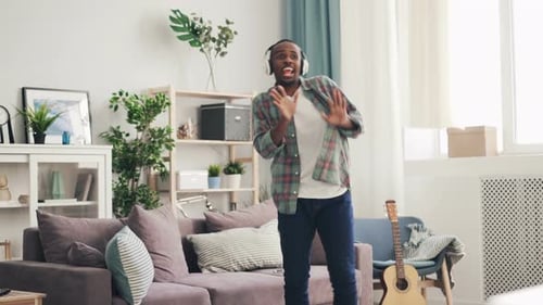 Happy Young Adult Dancing to Music at Home