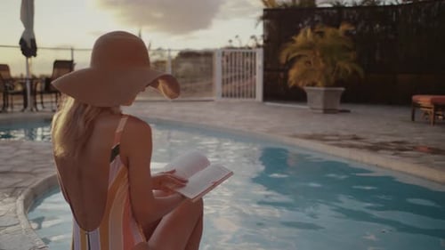 Woman Reading Book by Pool at Sunset