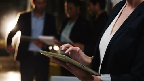Businesswoman Using Tablet with Colleagues in Office