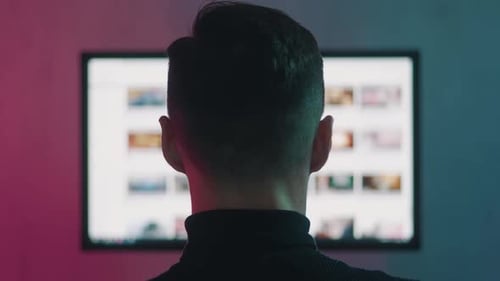 Mann mit Rückansicht beim Durchsuchen von Internetseiten auf dem Computerbildschirm. Surfen auf Webseiten, Konzept der Suche
