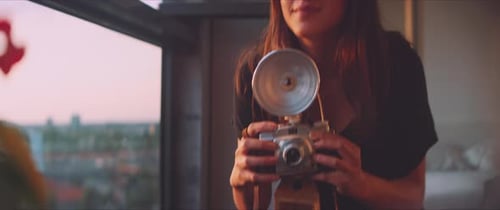Woman photographer taking a plant picture close up, shutter visible