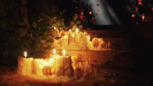 Flickering Melted Candles on Steps at Night