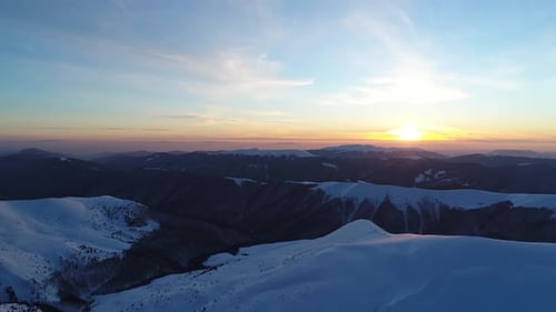 Aerial View of Snow Covered Mountains at Sunset