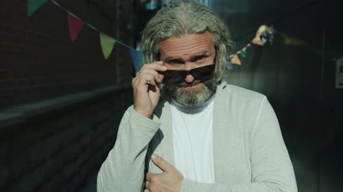 Confident Man with Gray Hair Smiling in Urban Alley