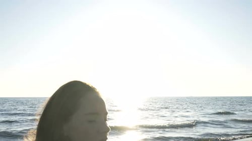 Young Caucasian Woman Practicing Yoga on the Beach Near Calm Sea