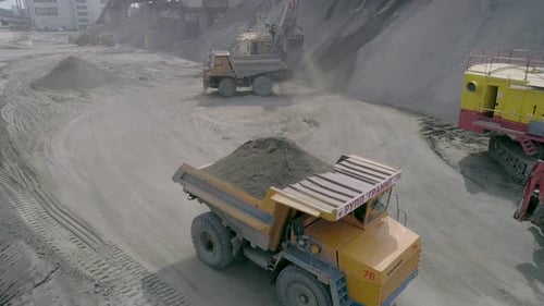 Heavy Mining Equipment Excavators, Large Dump Trucks, Front Loaders Working on Production of Crushed