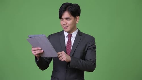Young Adult Man Using Tablet in Suit