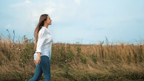 Young Beautiful Woman Walking in the Field