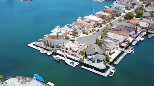 Vista aérea giratoria de hermosas casas multimillonarias de lujo frente a la bahía a lo largo de una cadena frente al mar