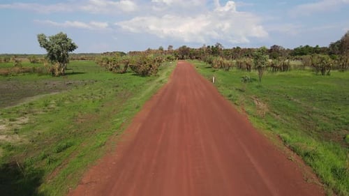 Low Fast moving drone shot Following Red Road moving Above Green Bushland near Holmes Jungle Nature
