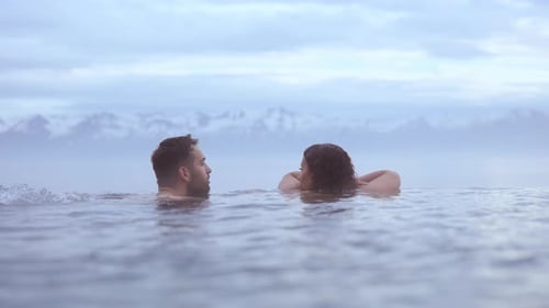 Couple Relaxing on a Hot Pool With the View of the Beautiful Snowy Mountain