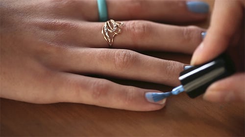 Woman Paints Nails a Light Blue Color
