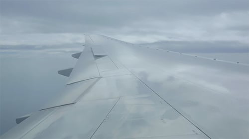Airplane Wing Flying Above the Clouds