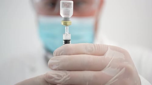 Gloved Hands Extract Vaccine Dose with Needle