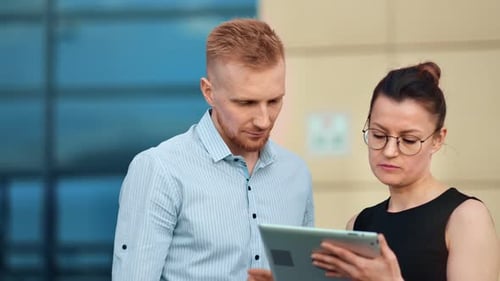 Two Professionals Collaborating with Tablet Outdoors