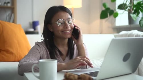 Woman Working at Home on Laptop and Phone