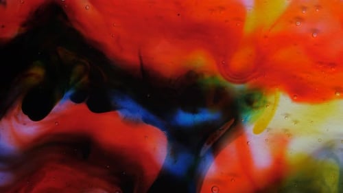 Transparent Space Liquid is Filled with Drops of Red Blue Yellow and Green Paint