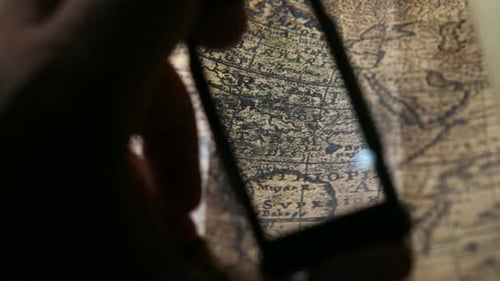 Examining Antique Map With Magnifying Glass