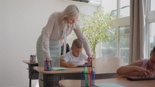 En la clase de la escuela primaria, un maestro entusiasta camina entre filas de niños brillantes y diversos
