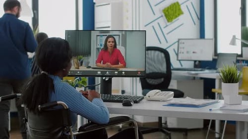 Woman in Wheelchair Attends Virtual Meeting in Office