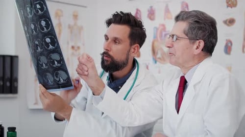 Handheld view of two busy doctors discussing some medical records. Shot with RED helium camera in 8K