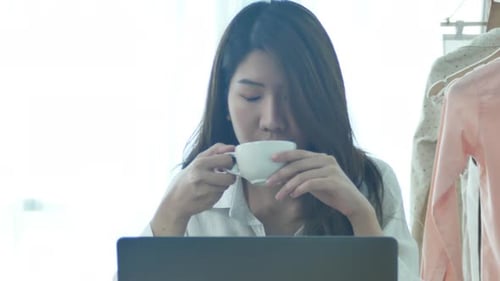 Woman Working on Laptop and Drinking Coffee