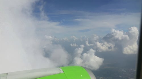 Airplane Wing Flying Through the Sky With Clouds