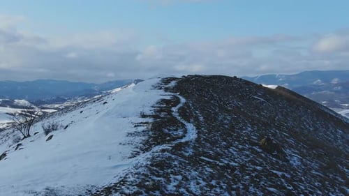 Runner on Snowy Mountain Ridge Aerial View