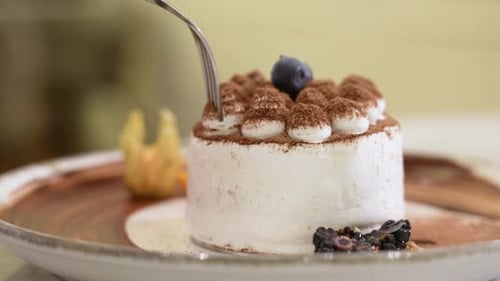 Fork Cutting Into Delicious White Frosted Cake