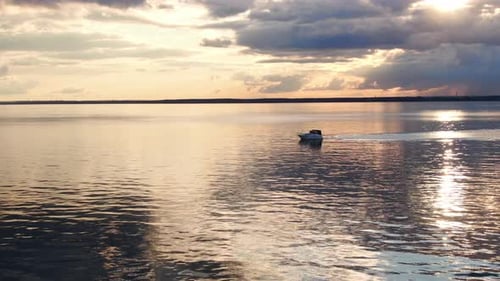 Boat Sailing on Lake at Sunset