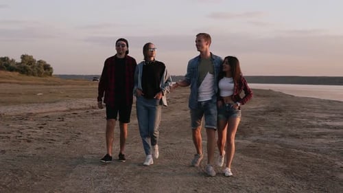 Friends Walking on Beach at Sunset
