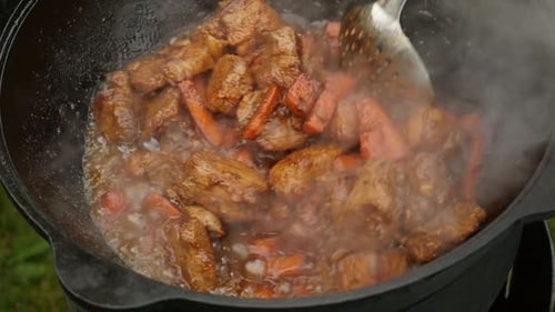 Meat and Carrots Cooking in Cast Iron Pot