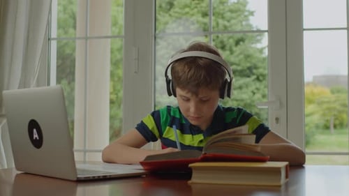 School Kid Writing with Pen Learning From Home