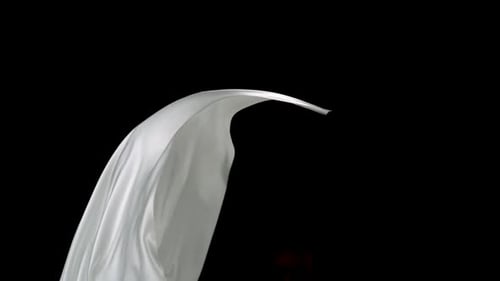 White Cloth Flowing in Slow Motion on Black